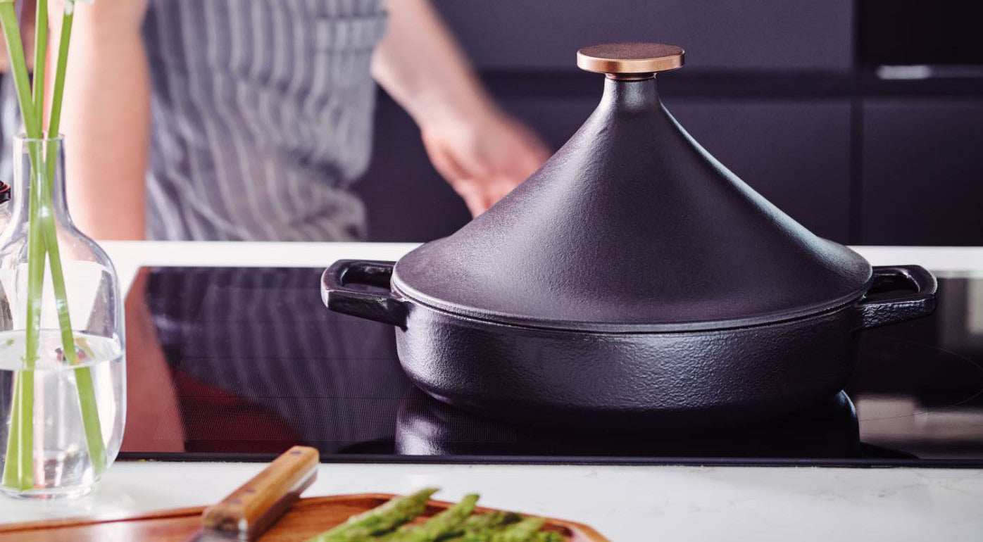 Cast iron tagine sits on a stove top