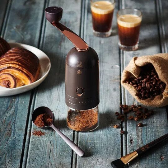 Coffee bean grinder with beans, espresso and croissant