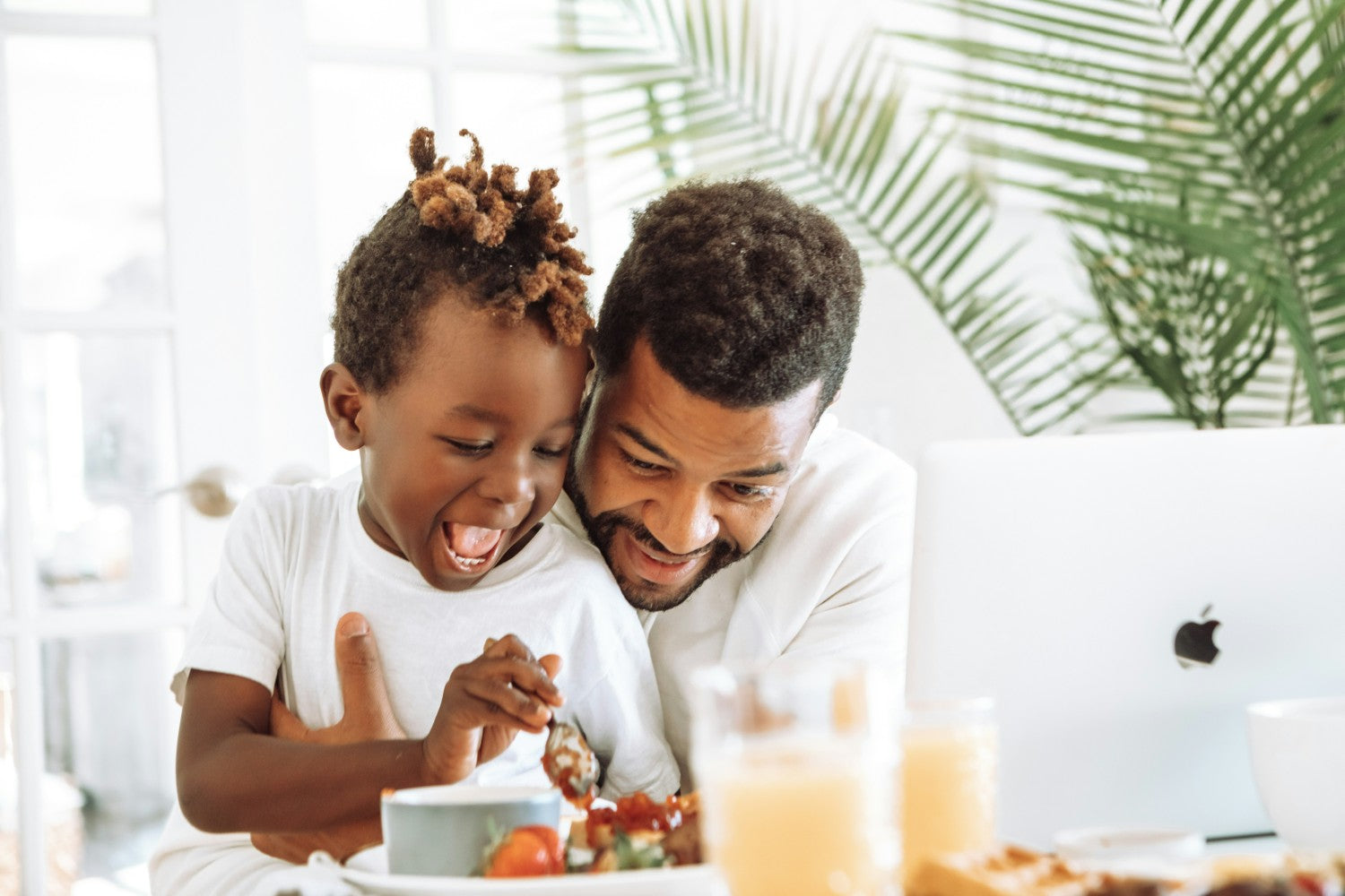 Father hugs child at a kitchen table