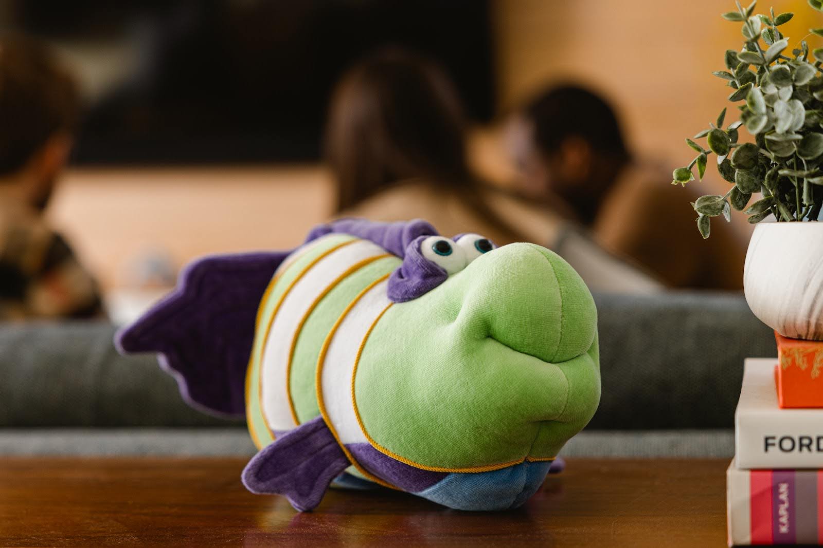Green and purple plush fish on a table