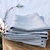 Portland Apron Company linen napkins folded on a wooden side table