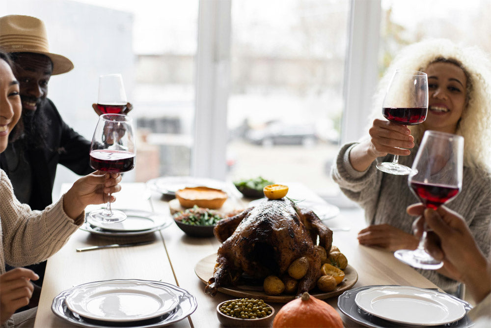 A family raising glasses over a simple Thanksgiving meal