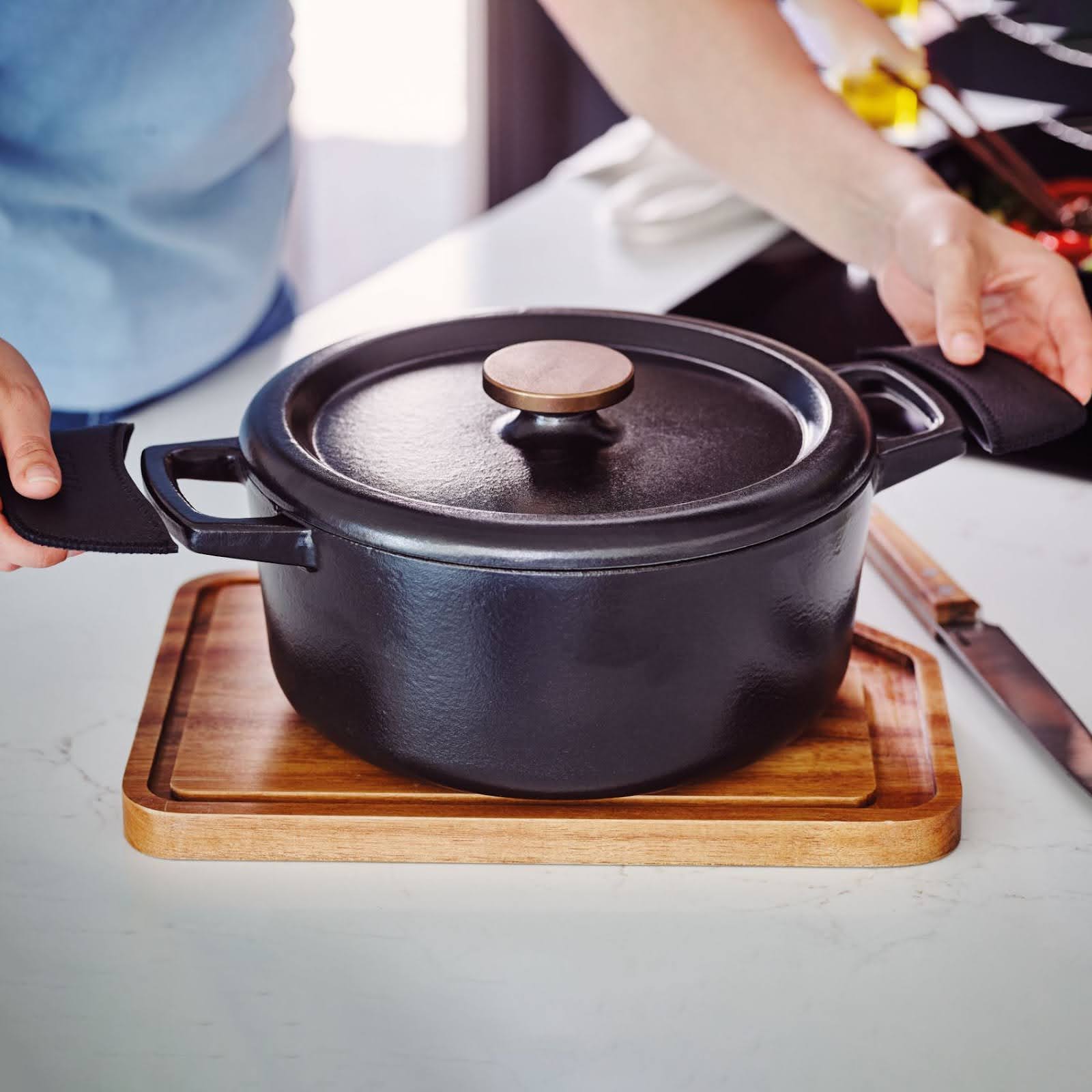 Person putting pot handle covers over a cast iron pot