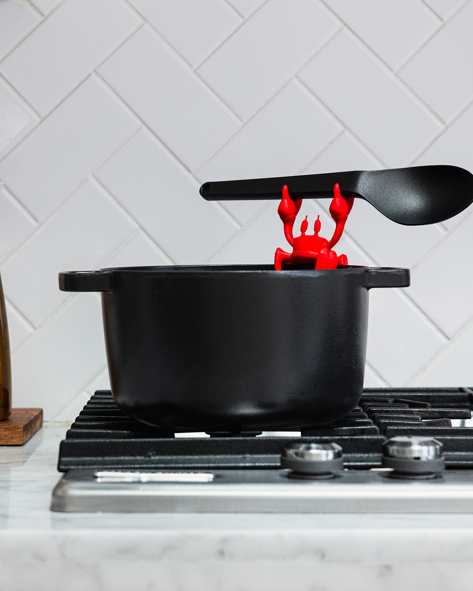 Red crab spoon holder on a pot holds a spoon