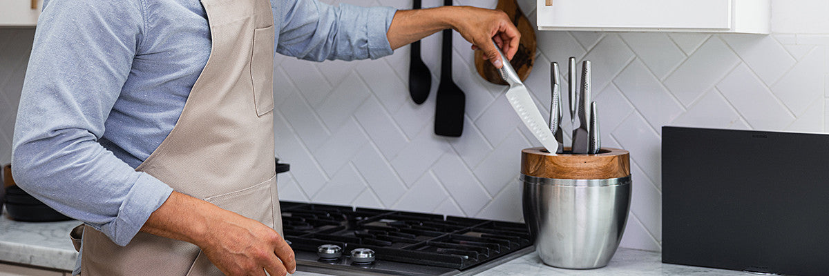 Man in apron removes a knife from the Cuisine Pro Egg Knife Block