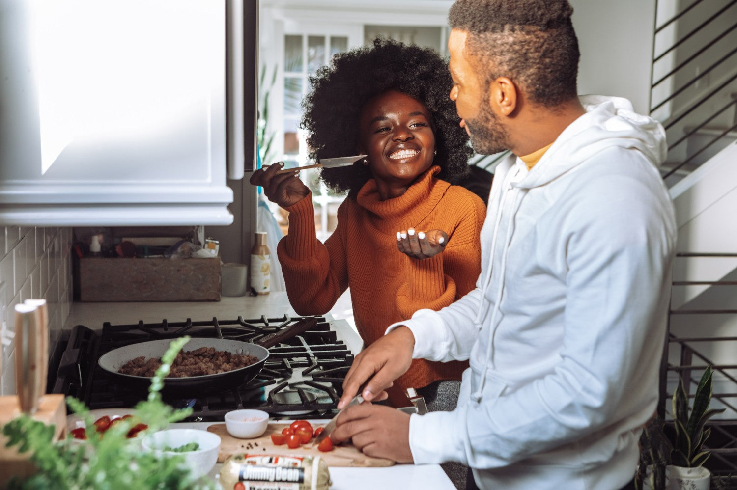 Man and woman preparing food in small space kitchen