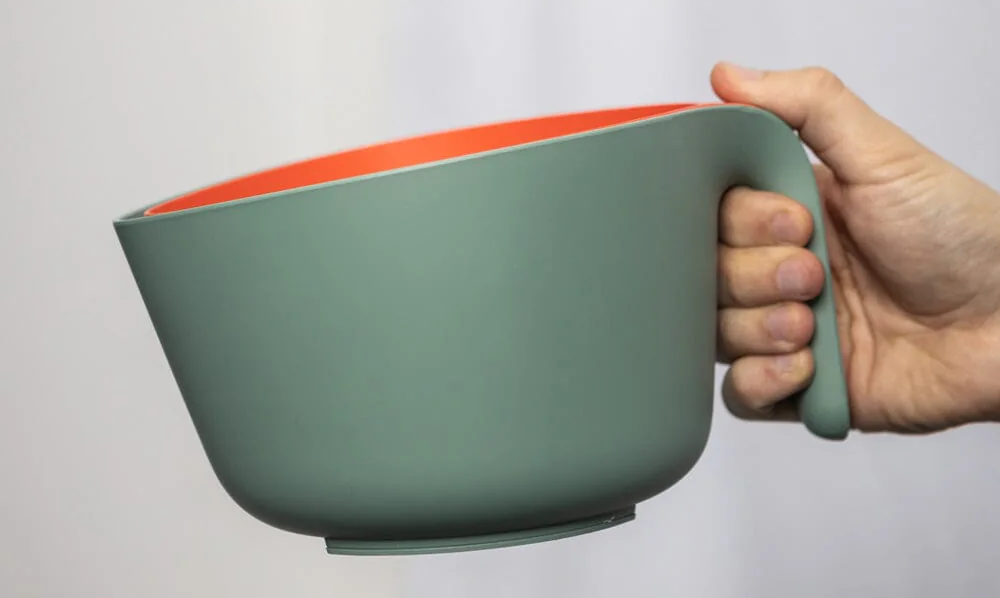 Hand holding sustainable salad bowl and strainer
