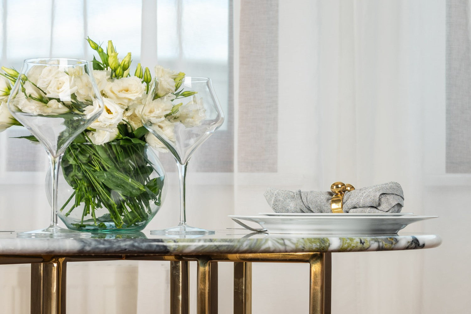 dinner table with wine glasses and white floral centerpiece