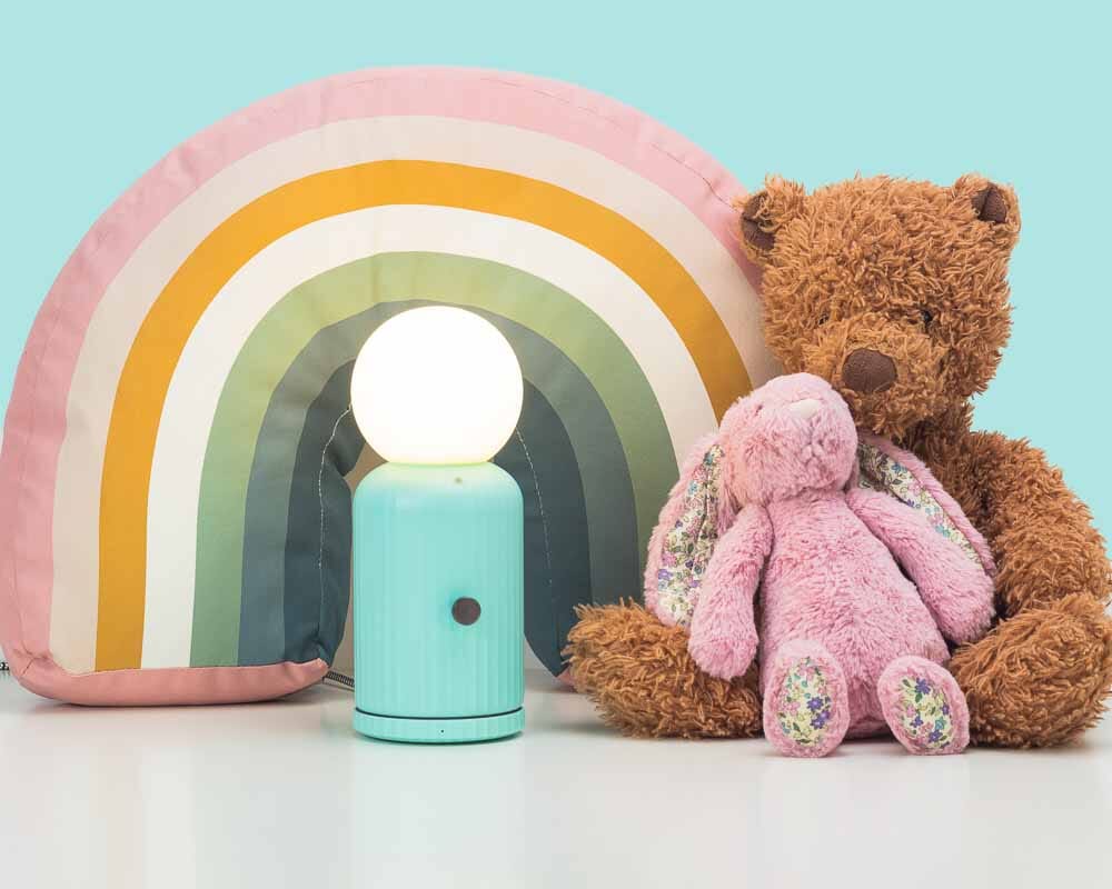 Teal LUND skittle lamp next to stuffed bunny and bear