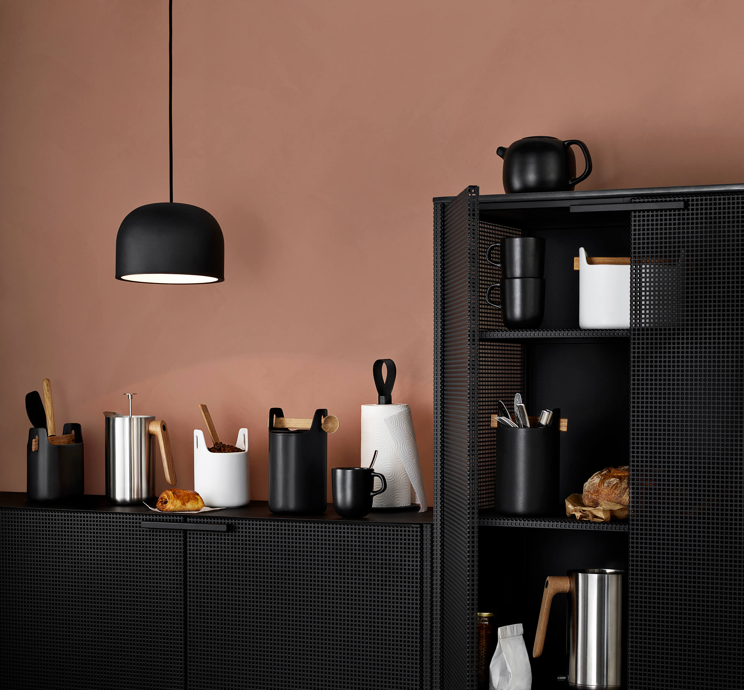 Utensil caddies on black sideboard with kitchen items