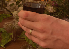 Mens 9ct yellow gold recycled wedding band, holding glass of red wine at the wedding