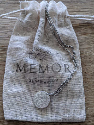 Memor Jewellery Pouch with Recycled Silver Aztec style necklace laying on it.