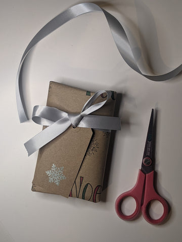 Memor Christmas wrapping with scissors and bow, all from recycled material and recyclable.