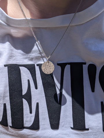 Silver hammered necklace being worn in the sun