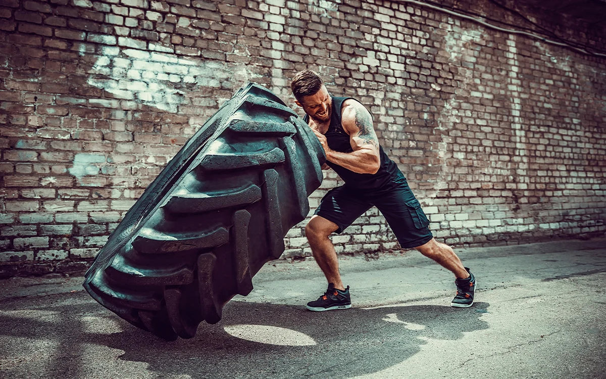 Man focused while lifting a large tire