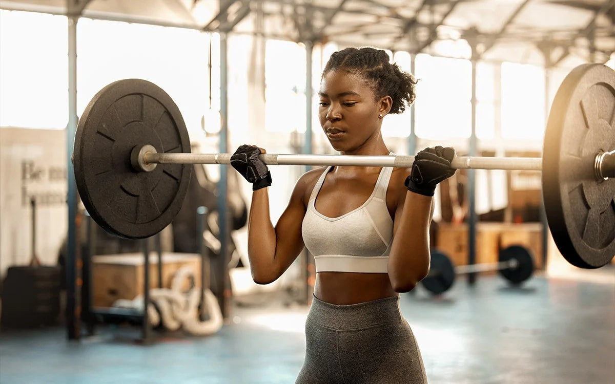 Woman Lifting Weights With Barbbell In Gym