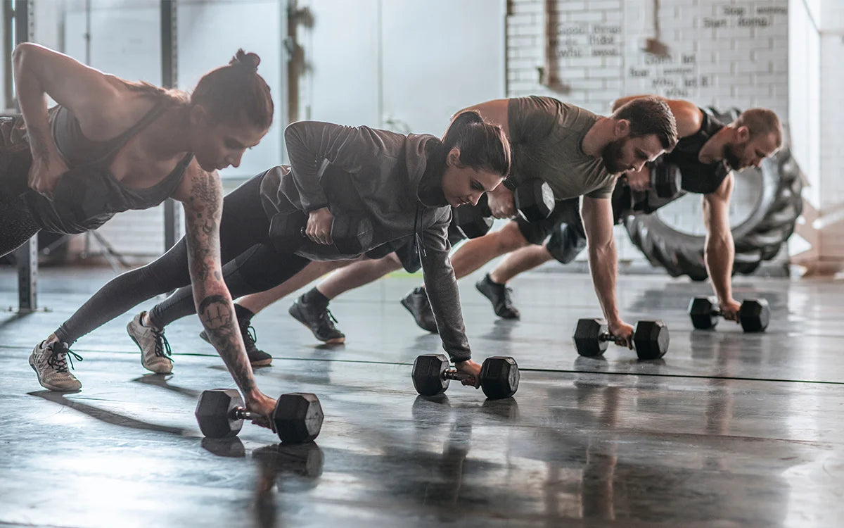 People Performing Dumbbell Rows In Gym Class