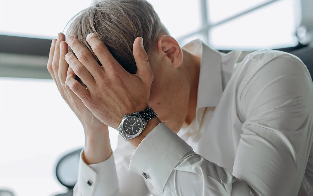 Tired man with head in his hands