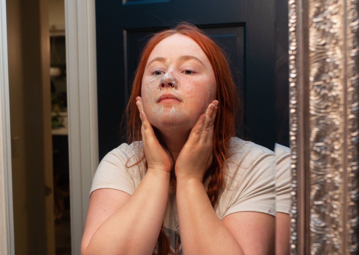 Young woman using acne soap on her face