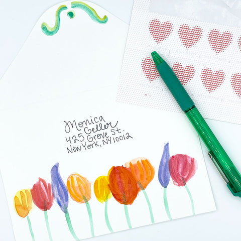 Colorful Watercolor Painted Floral Envelope with Heart Postage Stamps and Green Pen. Painted by Sunny Day Designs - Snail Mail Fun Blog Post