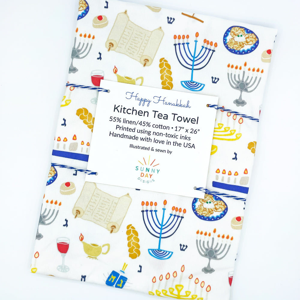 https://cdn.shopify.com/s/files/1/0430/4057/1556/products/Happy-Hanukkah-Tea-Towel-Packaged-Tilted-LowRes_1024x1024.jpg?v=1667264549