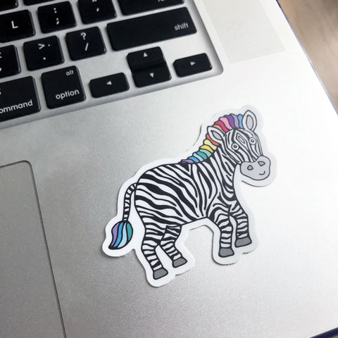 A colorful and cute zebra rare disease awareness sticker design shown on a macbook laptop