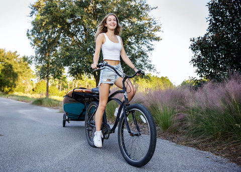 Paddle board wheels carrying a board on a bike by young girl