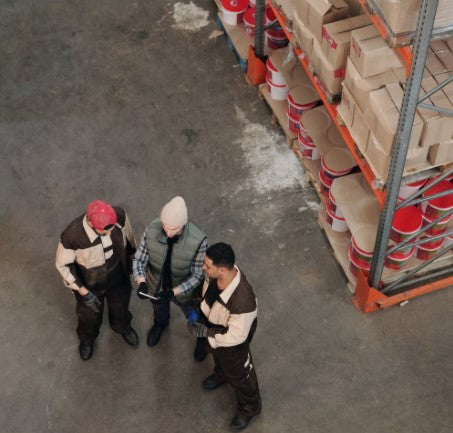 Three men talking in a construction warehouse