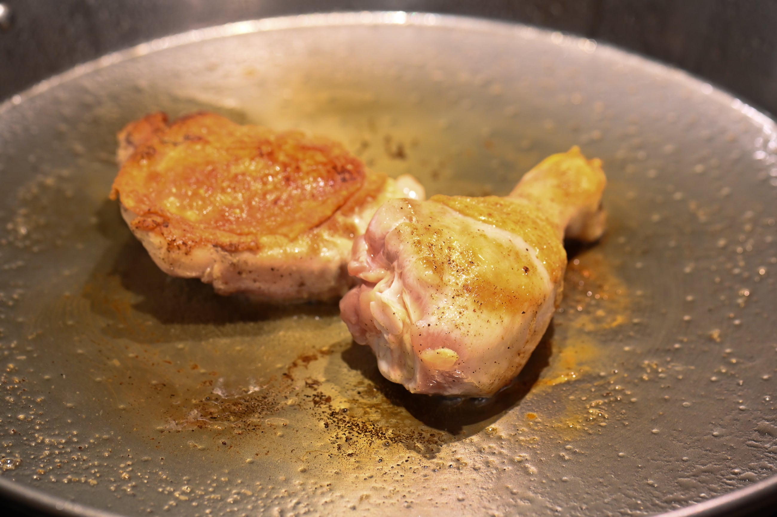 browning chicken leg and thigh in a paella pan