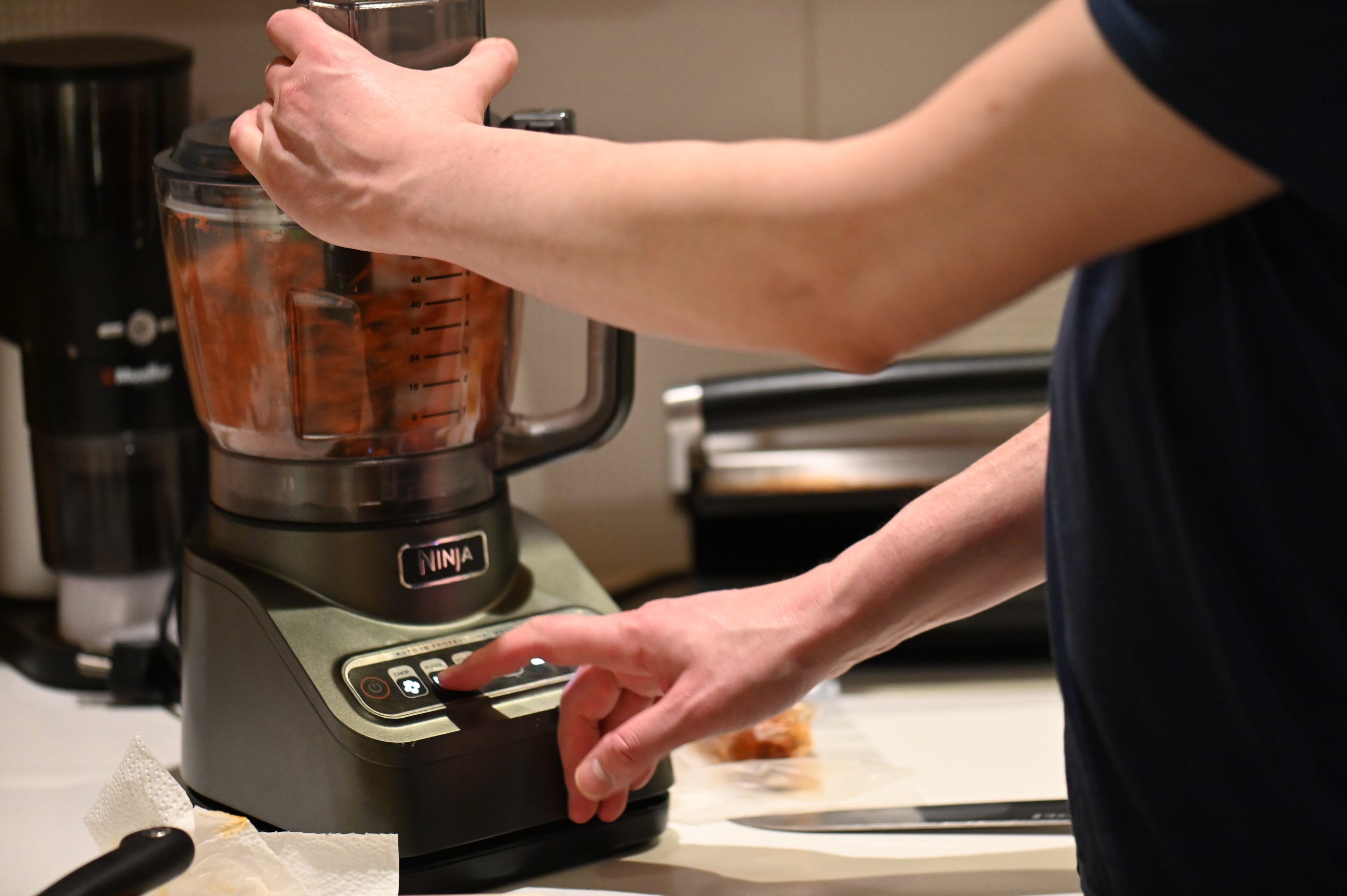 four star chef using food processor to grind up chorizo in a kitchen
