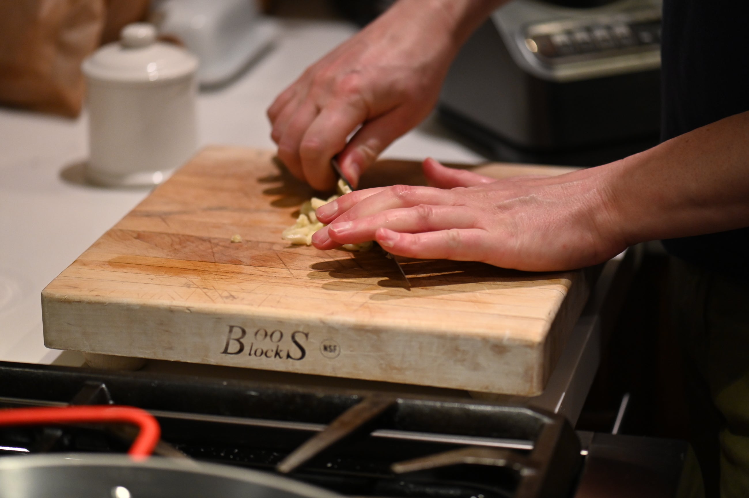 hands chopping garlic on a cutting board