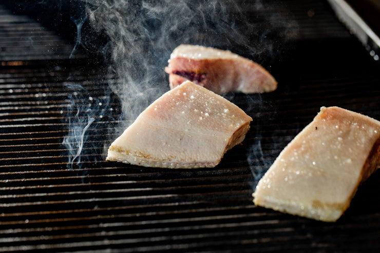 Turbot cooking on the grill with smoke