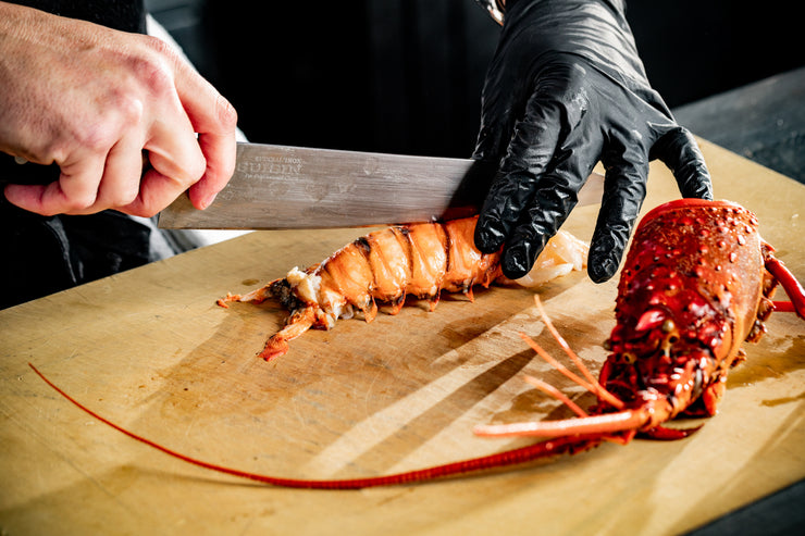 chef hands slicing spiny lobster tail