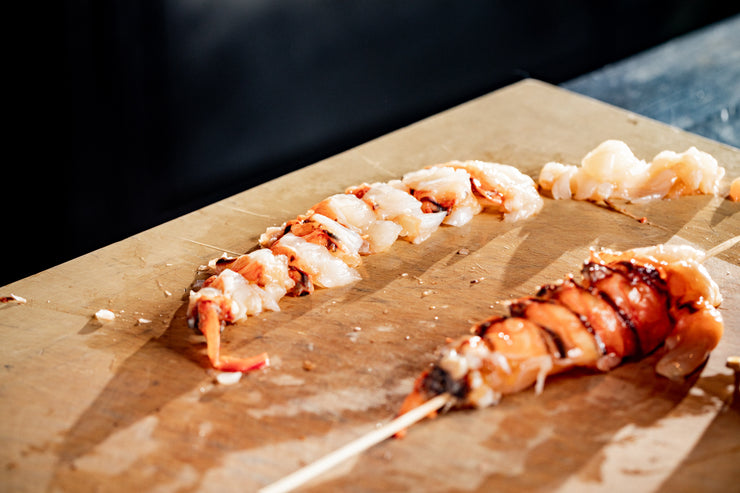 Sliced lobster tails on cutting board