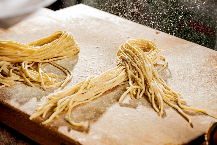 flour falling on fresh pasta on a cutting board in the kitchen