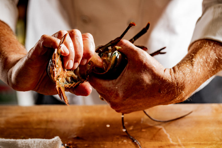 chefs hands twisting lobster tail