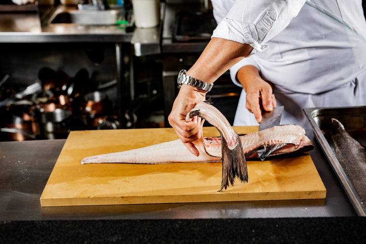 Chef removing backbone of black cod