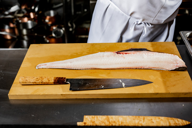 Black cod on cutting board with knife