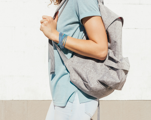 Woman carrying grey backpack.