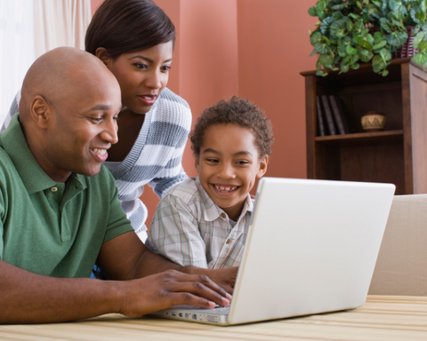 Father, mother and son sitting together and looking at something on computer.