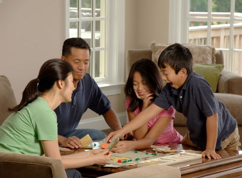 Family playing a fun game of Monopoly together.