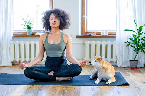 Woman meditating with pet dog 