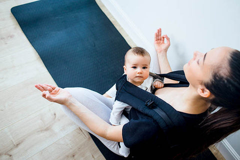 Mother meditating with baby in carrier