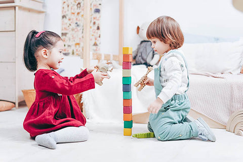 Two young friends sharing toy blocks