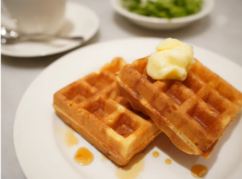 Waffles on a plate with syrup and butter