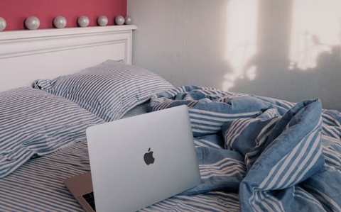 Laptop and pillows on bed