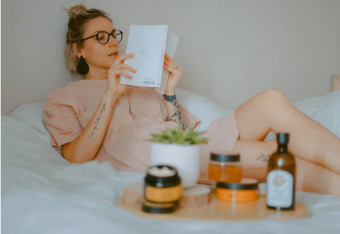 Woman reading in bed with candles