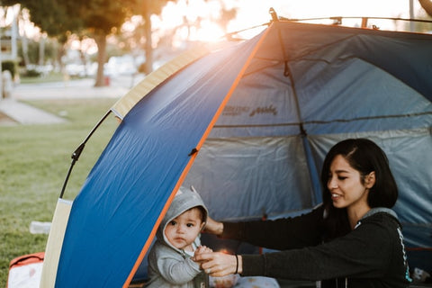Mother and young son camping out inside the tent
