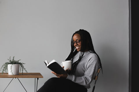 Woman sitting down and reading a book.