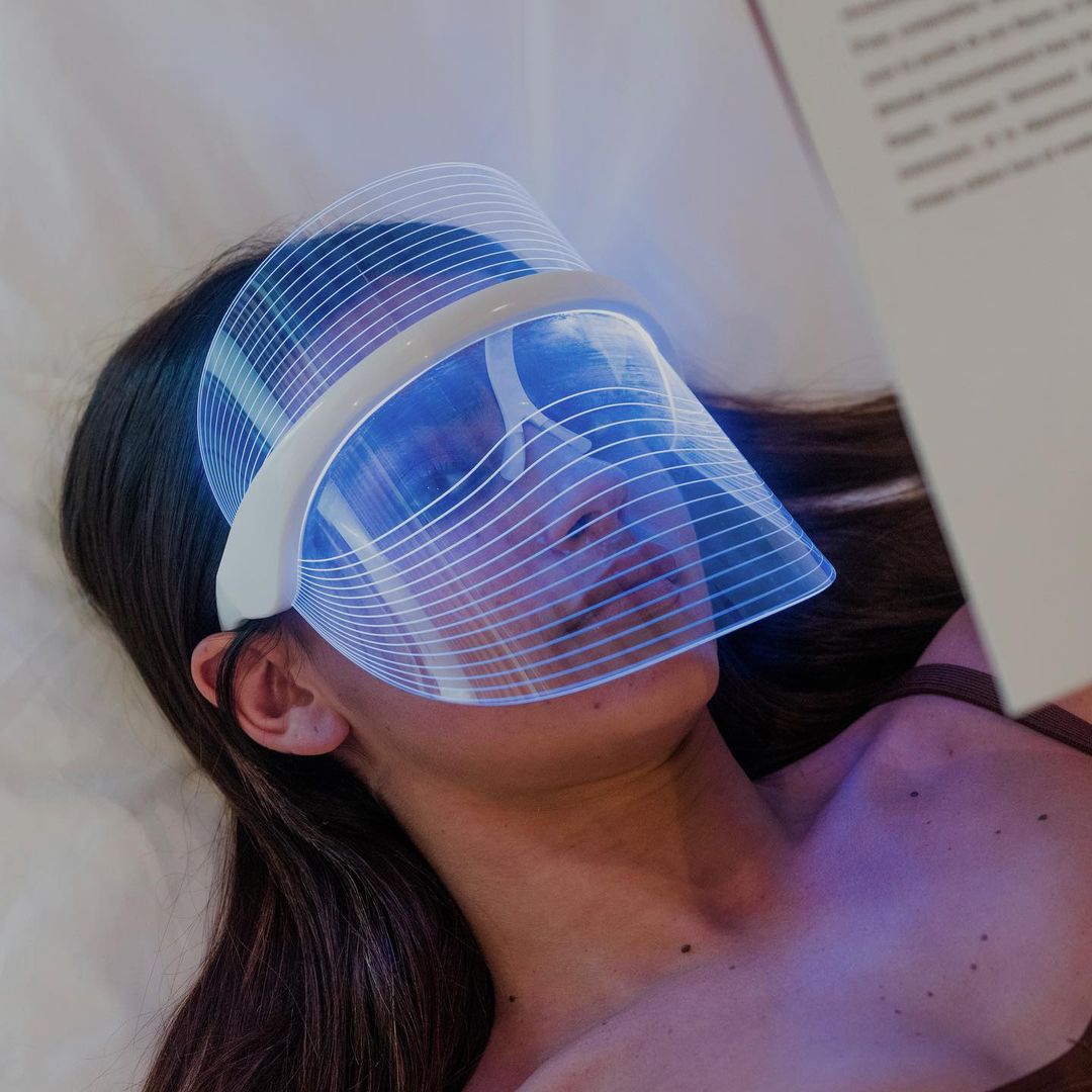 Frau entspannt sich mit der Luma Aesthetic Shield LED-Therapiemaske im Gesicht.